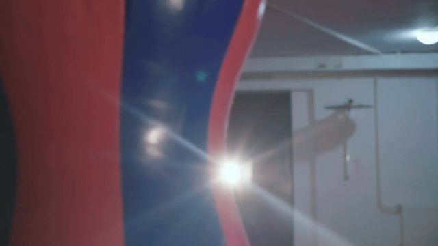 Pretty kickboxing woman training punching bag in sport studio in 4K