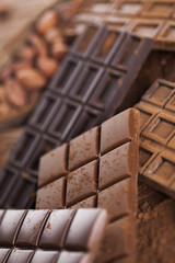 Dark homemade chocolate bars and cocoa pod on wooden