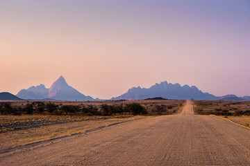 Fototapeta na wymiar Gravel road to Mt. Spitzkoppe, Namibia, at sunset.