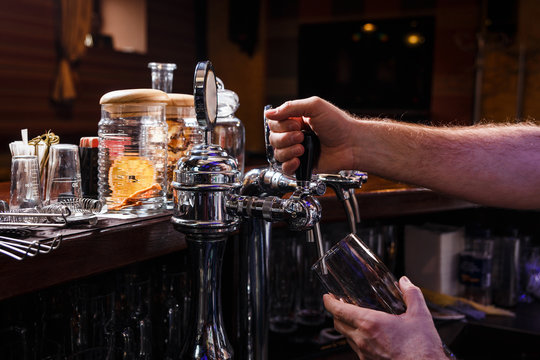 Close-up of bartenders hands pouring beer