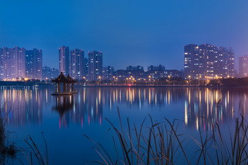 Fototapeta na wymiar buildings standing by riverside under dramatic sky,wuxi city,jiangsu province,China.