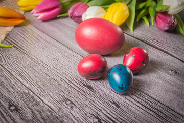 Obraz na płótnie Canvas Easter eggs and tulips on wooden background