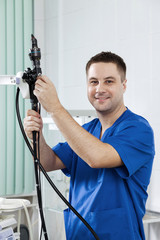Male doctor holding an endoscope.