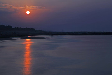 sunrise with a bright sun and the reflection of light on the sea