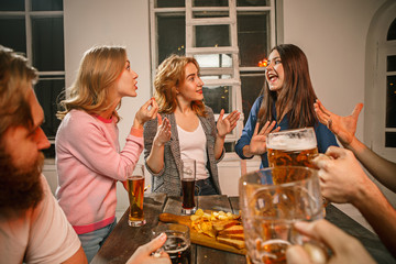 Group of friends enjoying evening drinks with beer