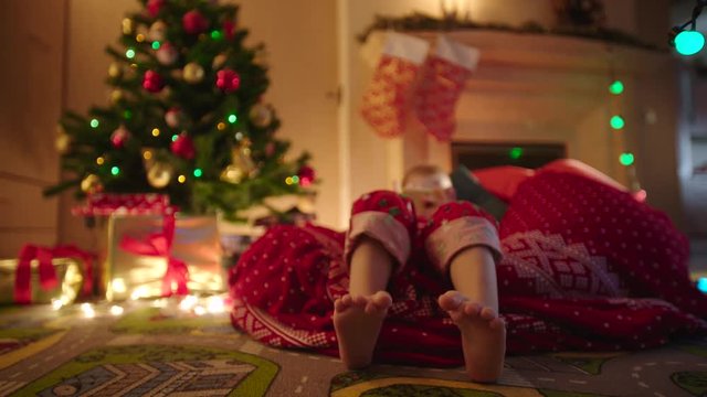 Close up of child feet dancing while waiting for Santa Claus coming on Christmas night