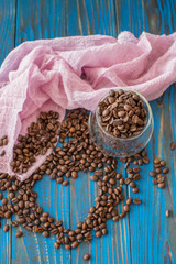 Heart from the coffee beans on the blue wood background, to the day of Valentine