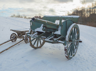 Fototapeta na wymiar winter in the field is a cannon of the second world war.