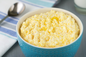 Corn porridge in a blue bowl on a wooden table