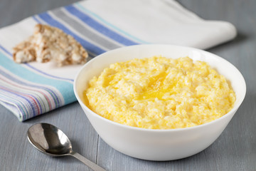 Corn porridge in white bowl on wooden table