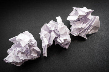 Crumpled paper on a black background. Selective focus.