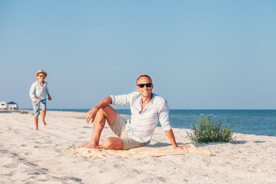  Father with son relax on sand sea beach