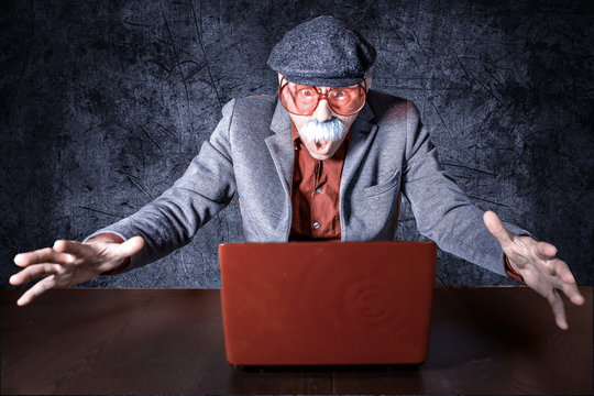 Senior sitzt vor Computer und lernt