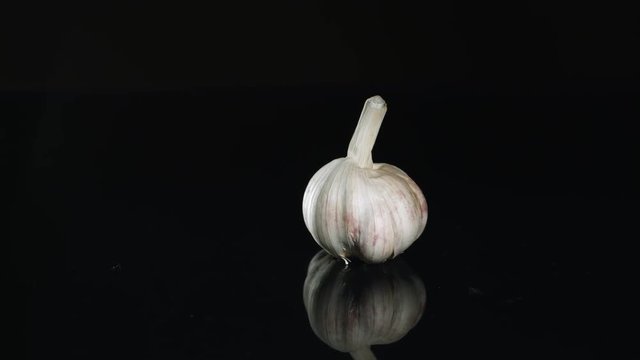 Whole garlic rotating on reflective surface