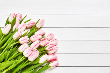 Bouquet of pink tulips on white wooden background. Top view, copy space 