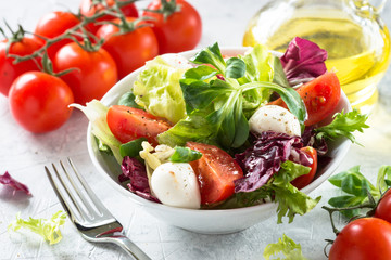 Fresh salad in a bowl. Green leaves tomatoes mozarella. Organic diet food