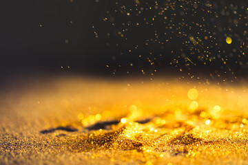 Sprinkle gold dust on a black background with copy space