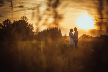 love story man and woman on the background of haystacks sun
