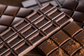 Dark homemade chocolate bars and cocoa pod on wooden