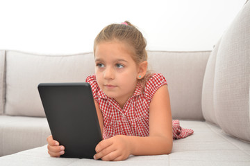 Toddler girl playing games on her tablet