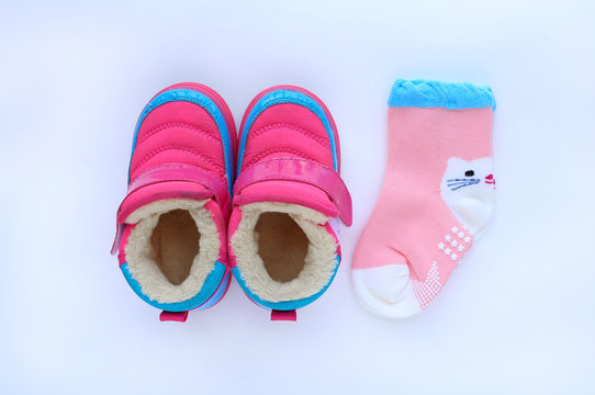 Cute baby shoes with socks on white background. Top view