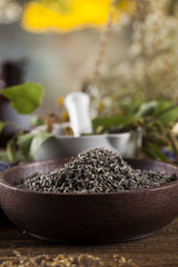 Assorted natural medical herbs and mortar on wooden table background