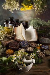 Herbal medicine and book on wooden table background