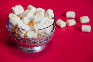 Air marshmallows in glass vintage vase on a red background. The delicious taste of marshmellow in restaurants and cafes.