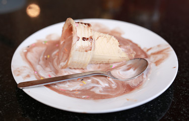 melting ice cream cone on dirty dish