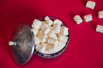 Air marshmallows in glass vintage vase on a red background. The delicious taste of marshmellow in restaurants and cafes.