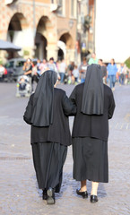 two nuns blacks with long dresses and a veil to cover the hair