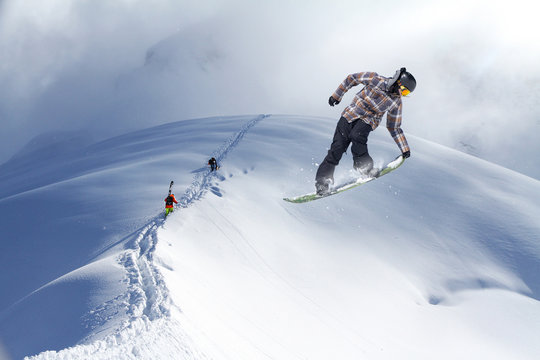 Jumping snowboarder in winter mountain. Extreme sport.