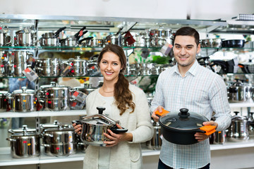 Cheerful positive  couple in the cookware section