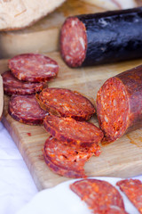 red sliced sausage on wooden board