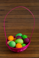 Easter eggs in the basket of wooden boards.