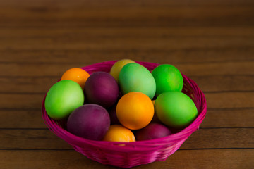 Fototapeta na wymiar Easter, Easter eggs in basket on a brown wooden background