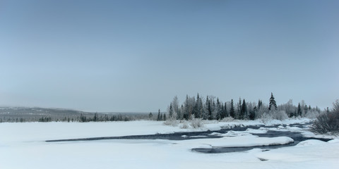 Winter landscape with unfrozen river in Russian Lapland, Kola Peninsula