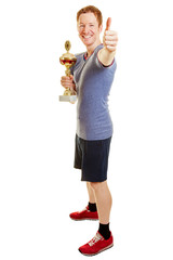 Mann als Sieger mit Pokal hält Daumen hoch