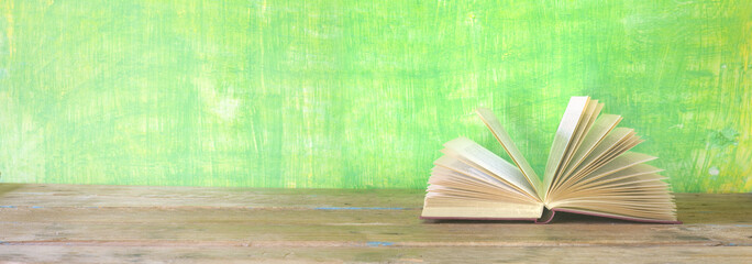 Fototapeta premium open book on green grungy background, good copy space