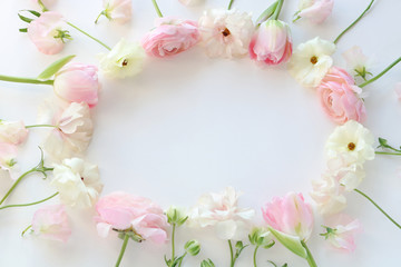 Frame of beautiful pink and white ranunculus flowers, sweetpea, and tulip flowers on white background