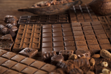 Dark homemade chocolate bars and cocoa pod on wooden