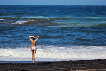 The redhed young woman standing at the sea