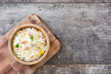 Fried chinese rice with vegetables on wooden table
