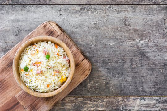 Fried chinese rice with vegetables on wooden table
