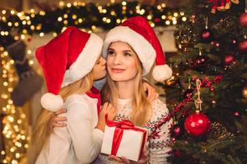 Fototapeta na wymiar Happy mother and daughter in santa hats