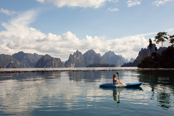 Young female enjoy kayaking on mountain tropical lake