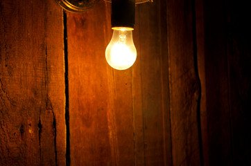 Electric light bulb on wooden background