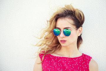 Portrait of Beautiful Fashion Woman in Sunglasses. Trendy Romantic Girl in Summer. Stylish Lovely Female. White Wall Background Copy Space. Not Isolated Toned Photo.
