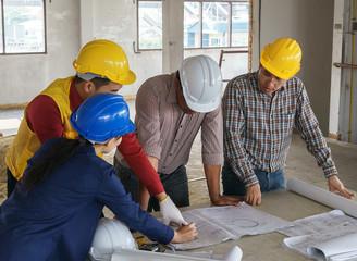 business people group on meeting and presentation with construction engineer architect looking building model and blueprint plans