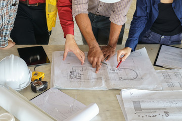 business people group on meeting and presentation with construction engineer architect looking building model and blueprint plans